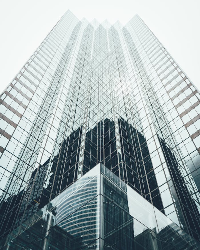 Striking low angle view of a modern skyscraper with reflective glass facade in a cityscape.