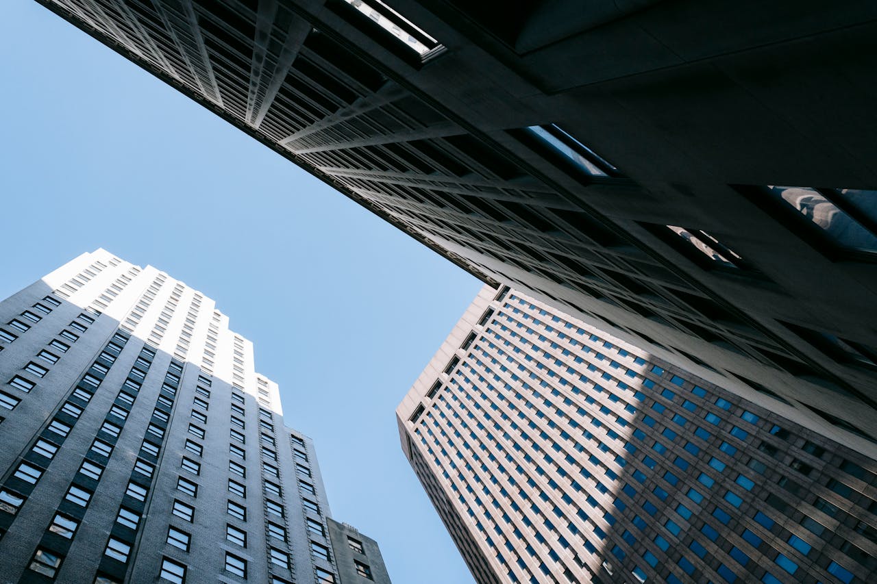 From below of contemporary high multistory office skyscrapers located in downtown against blue sky